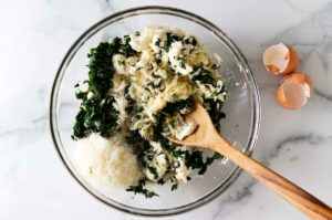 Stirring the cheese and spinach filling mixture.