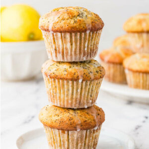 Three sourdough poppy seed muffins with a lemon in the background.