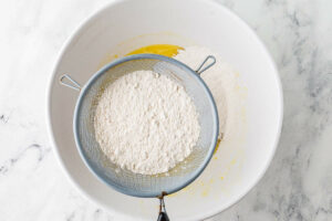Sifting the dry ingredients into the mixing bowl.