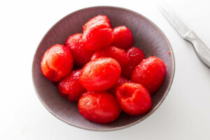 Several tomatoes with the skins peeled.