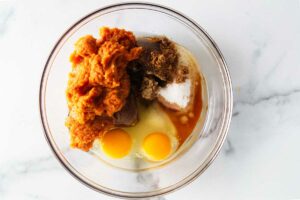 Mixing pumpkin puree with eggs, sugar and spices.