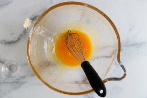 Whisking egg yolks in a mixing bowl.