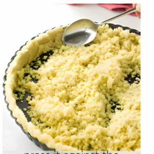 Showing how to press shortbread pie dough into a tart pan.
