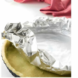 Placing foil over shortbread pastry dough.