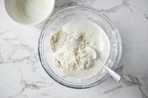 Adding cream to scone batter.