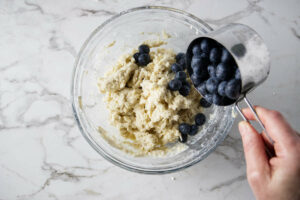 Adding blueberries to sourdough scone dough.
