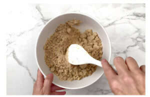 Mixing a crumble topping in a bowl.