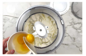 Adding eggs to the sourdough cake batter.