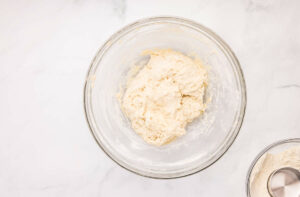 Mixing pizza dough to a shaggy dough.