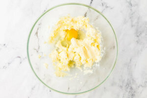 Adding eggs to creamed butter and sugar.