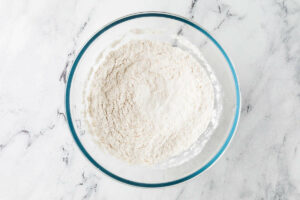 Mixing flour and other dry ingredient in a bowl.