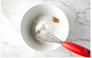 Using a whisk to blend the dry ingredients.