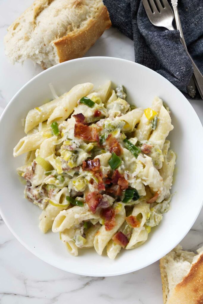 A pasta bowl filled with bacon and leek pasta.