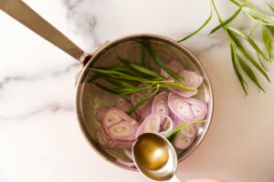 Shallots, vinegar and tarragon in a saucepan.