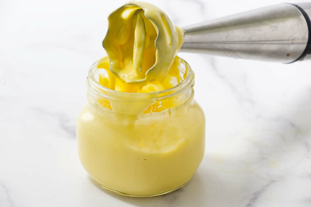 An immersion blender over a jar of homemade Béarnaise sauce.