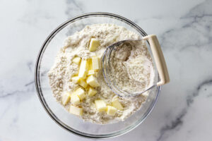 Blending butter into flour mixture with a pastry blender.