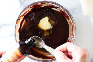Adding hazelnut extract to chocolate filling.
