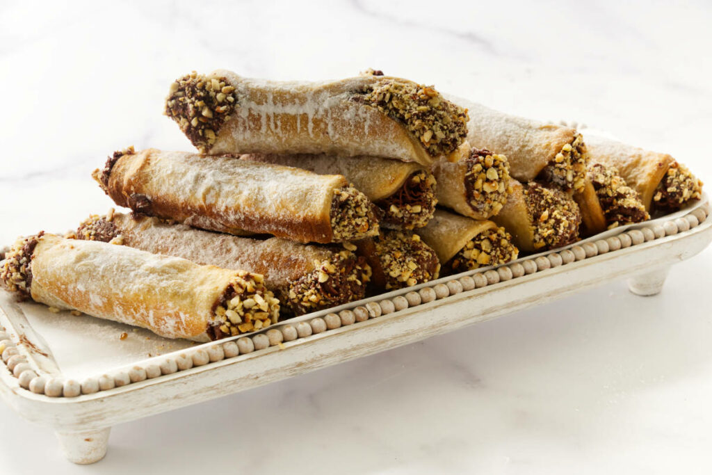 Several chocolate hazelnut cannoli pastries on a plate.