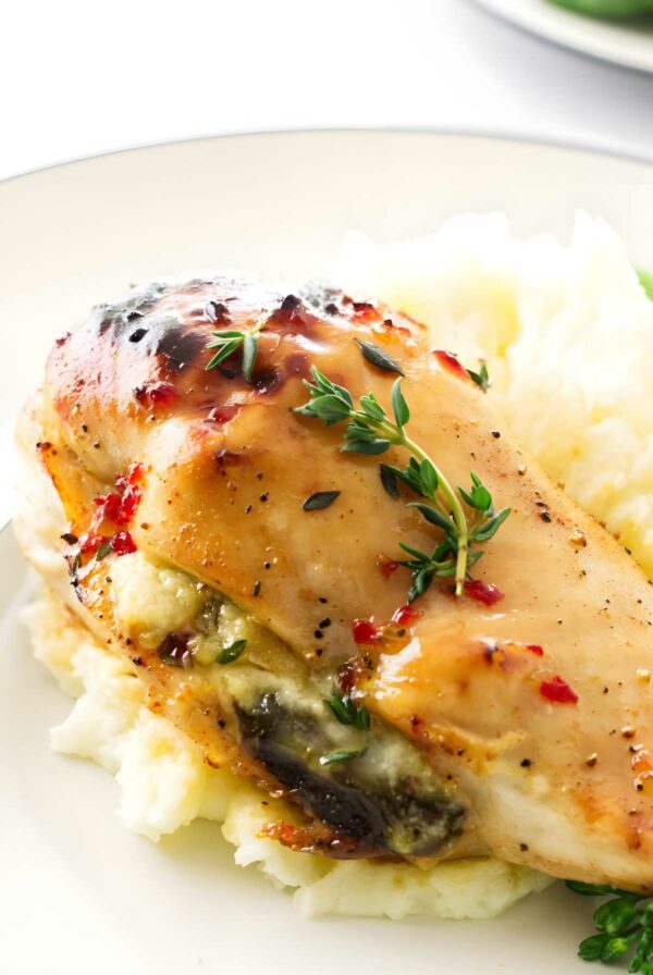 Stuffed chicken breast with cheese, fresh thyme, on mashed potatoes.
