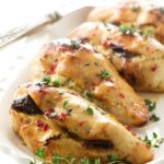 Stuffed chicken breast on a white plate.