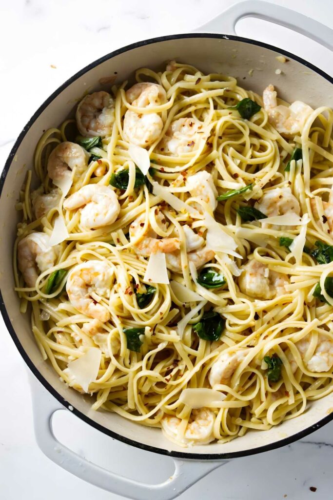 Pan of pasta with lemon shrimp, basil, and parmesan cheese.