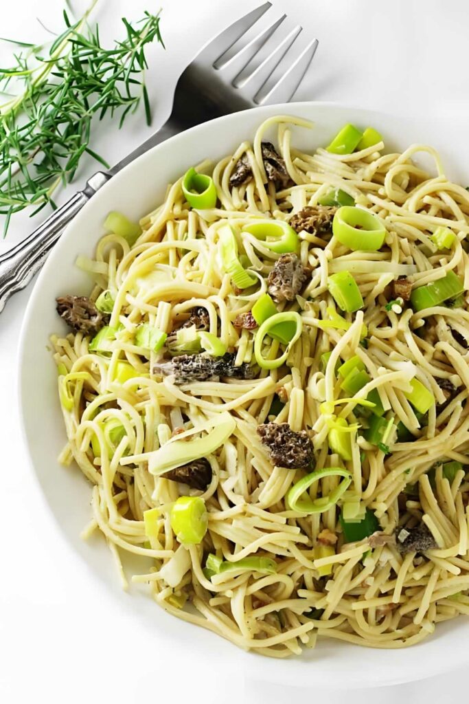 Goat cheese sauce and morel mushrooms with pasta in a dish.