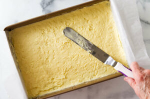 Spreading the buttercream pastry over the top of the nanaimo base.