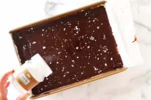 Adding flaky salt to the top of the nanaimo bars.