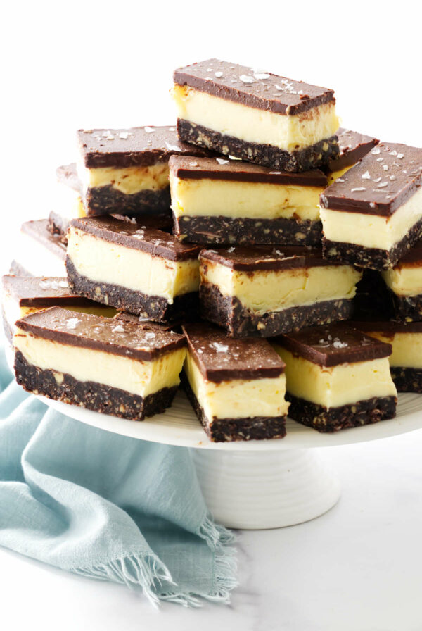 Several thick nanaimo bars on a dessert platter.