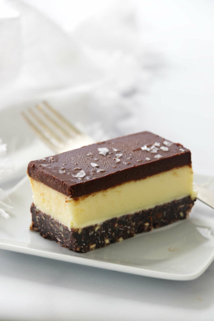 A layered nanaimo bara on a plate with a fork.