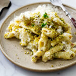 Creamy pistachio pasta on a dinner plate with a fork.