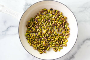 Toasting pistachios in a skillet.