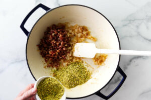 Adding crushed pistachios to the skillet.