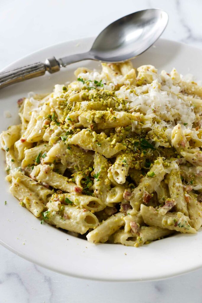 A pasta bowl filled with penne pasta and pistachio sauce.