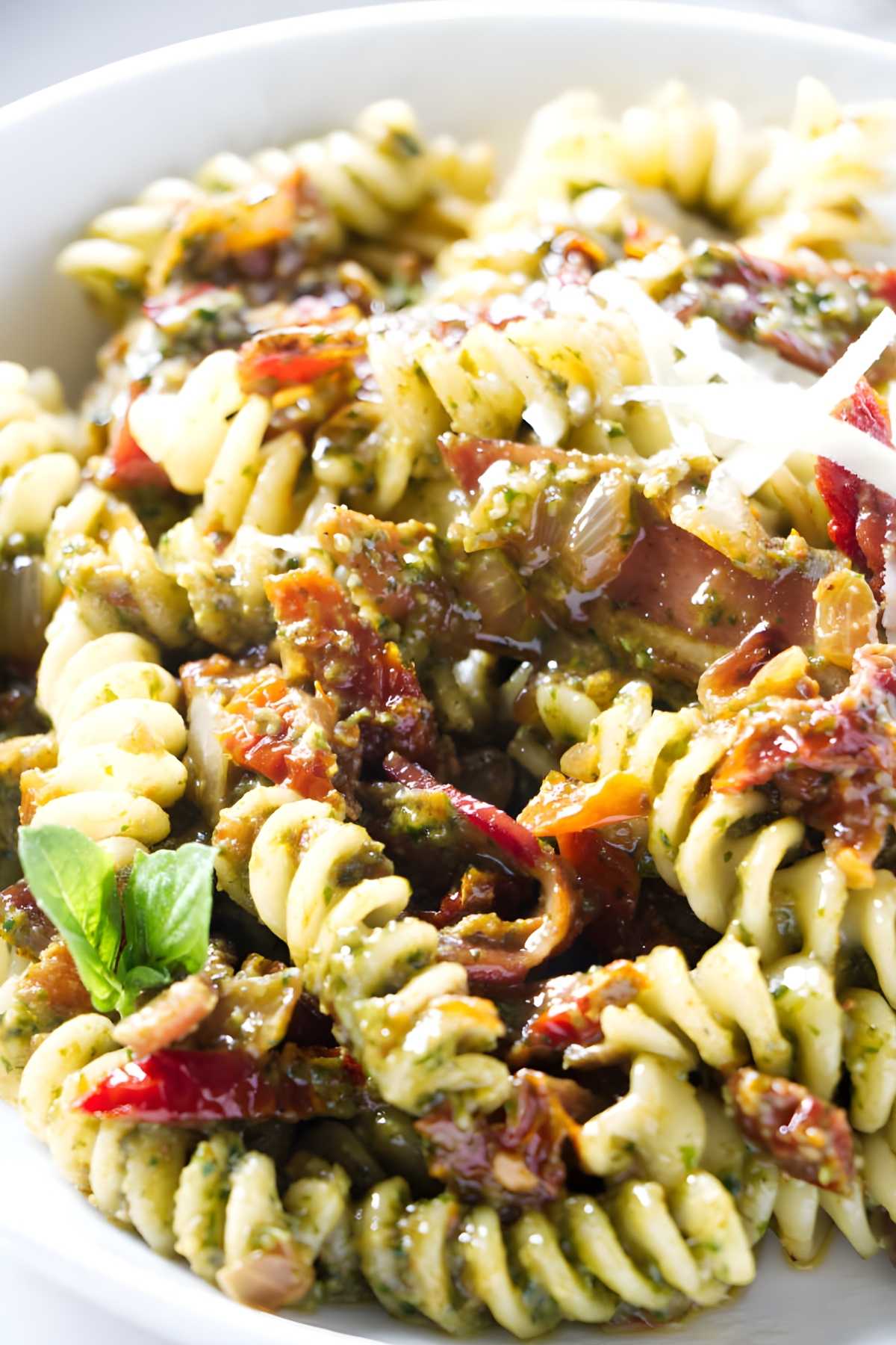 Pasta with green pesto, sun-dried tomatoes, basil, and Parmesan cheese.