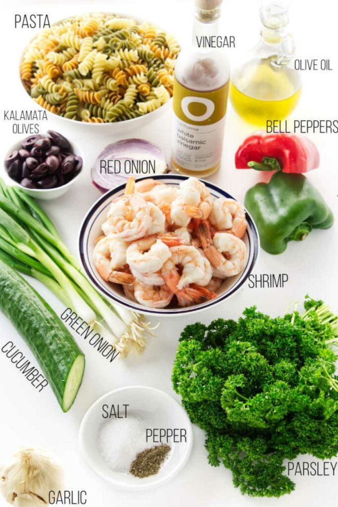Shrimp pasta salad ingredients arranged on a white surface.