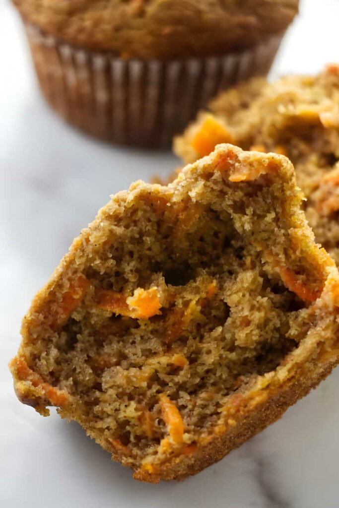 Close-up of a halved carrot muffin with moist texture and visible shreds.