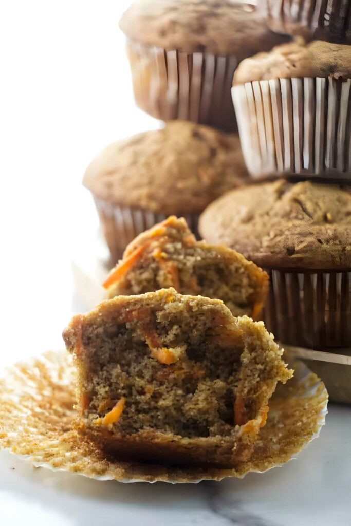 A partially eaten carrot muffin with spelt flour. 