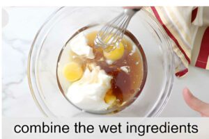 Hand whisking eggs, yogurt, and liquids in a glass bowl. Text: combine.