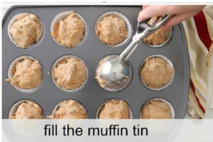 Hand scoops batter into lined muffin tin; text reads, fill the muffin tin.