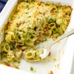 Partially served pasta casserole in white dish with tuna.