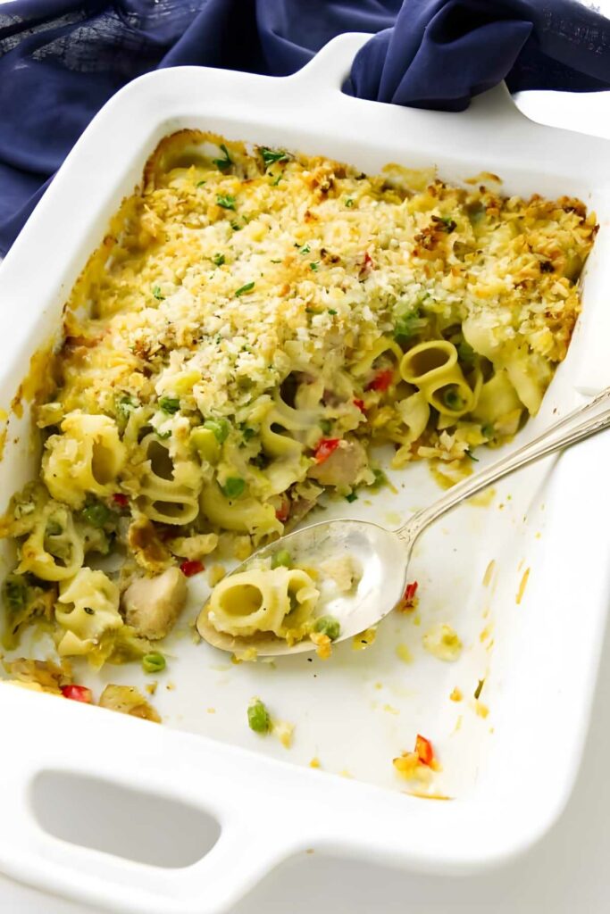 Partially served pasta casserole in white dish with tuna.