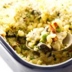 Creamy tetrazzini in casserole, spoon lifting a serving.