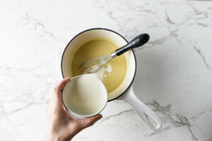 Adding cream to the dijon sauce.