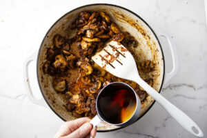 Pouring marsala wine into the skillet.