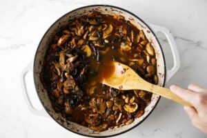 Adding marsala and wild mushrooms to the sauce.