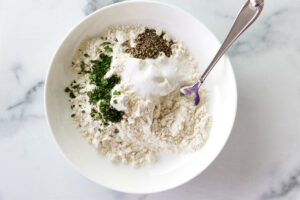 Mixing flour and spices in a bowl.