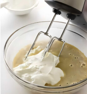 Beating the wet ingredients for muffins in a mixing bowl.
