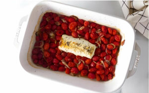 Roasted tomatoes in a casserole dish with goat cheese