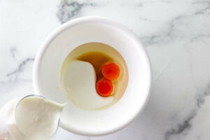 Adding buttermilk to the mixing bowl.